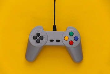 Video game Gamepad. Gaming concept. Top view retro joystick on yellow background.