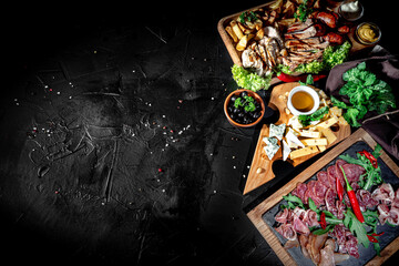 Grilled meat with sauces with various kind of cheese, on dark background. Mix of different snacks and appetizers
