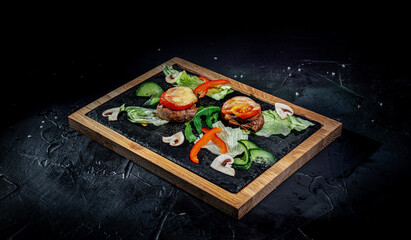 Beef filet mignon with vegetables on dark background