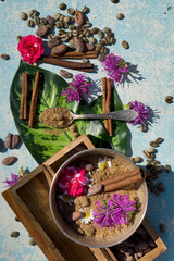  flat lay  concept with raw cocoa and coffee beans , cocoa powder,twig of cinnamon,  leaf and flower  as  ingredien for recipe  on wooden rustic blue   background,