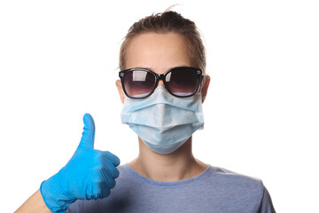 Woman in protective mask, sunglasses gloves shows thumb up isolated on white background