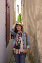 Tourist woman walking in narrow streets of small town