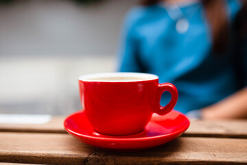 Hot coffee with latte art in a white cup with saucers on a wooden table. Cappuccino with foam. Cup of coffee on a wooden table. Top view. Place for text. Cappuccino with latte.