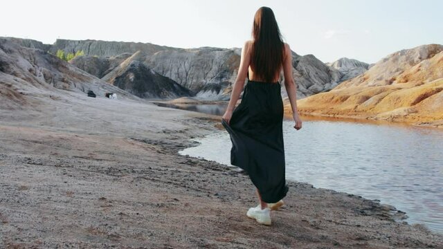 Beautiful woman walking on other-worldly hilly landscape