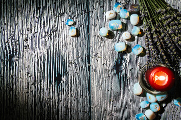 Wooden table with occult attributes, top view. Rune stones, candles, dry lavender. Empty copy space