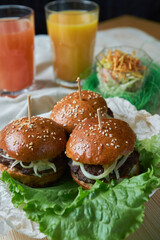 Juicy mini burger with onion rings, jalapeno pepper, cucumbers, lettuce, cheese on a white background