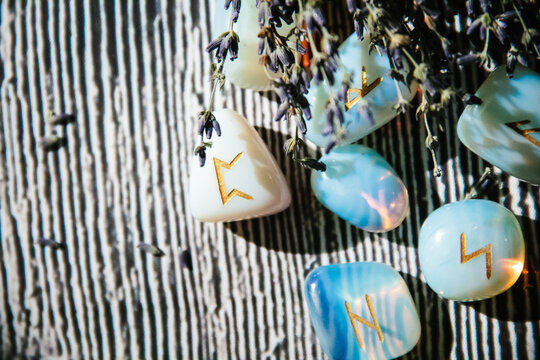 Close up of rune stones on wooden table. Occult and magic symbols. Empty copy space