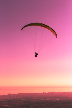 Towards to sunset. Paragliding is a sky sport. A paragliding can carry one or two people. You float in the air but the paragliding are for slowing down the speed while falling.