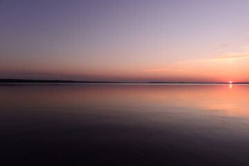 Tranquility sunset on the lake under the cloudless sky