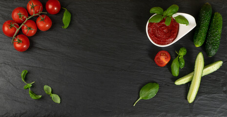 Dark Stone Background with Cucumbers, Tomatoes and Greens