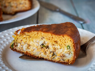 A serving of fish and rice cake on a white ceramic plate close-up
