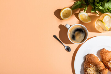 top view of coffee and croissants for breakfast on beige table with copy space