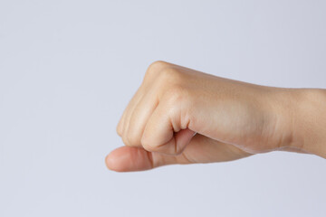 Gesture and sign, female hand fist on a white background. Hit on the object