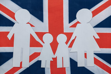 Paper cut family chain on background of British flag. Patriotism theme