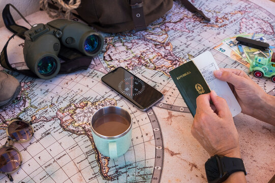 Senior people planning vacation trip on a world map checking passport. Money and travel accessories - active retired elderly concept