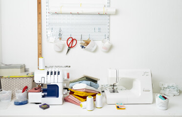 Fototapeta na wymiar Workplace: White table with a sewing machine and an overlock for sewing.