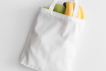 White tote bag mockup with fruit on a white table.