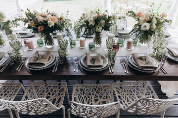 Flower decoration of wedding tables.
Banquet table setting and decoration. Cutlery on the table. 
