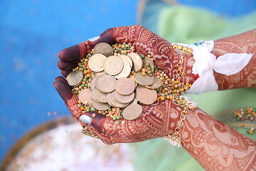 Girl's hand in golden coin in  Indian traditional wear Hindu culture wedding celebration 