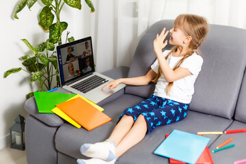 Photo of little pretty pupil school lady turn on skype laptop notebook online lesson hold open book...