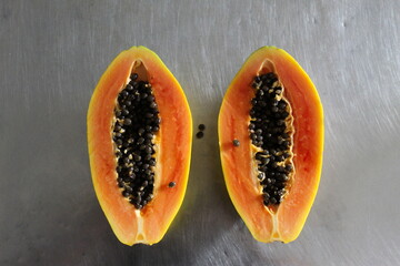 Papaya fruit cut in half on the kitchen table.