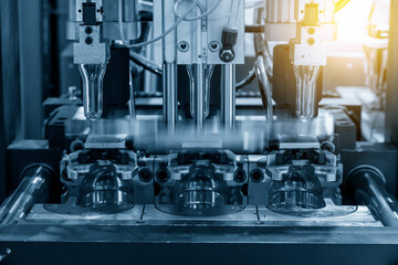 The tube preform shape of bottles preheat process on the production line to the automatic blowing machine. The operation of PET bottle processing by blowing process with the blowing mold.