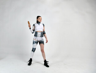 beautiful girl in a robot suit as a housewife with a rolling pin in her hands