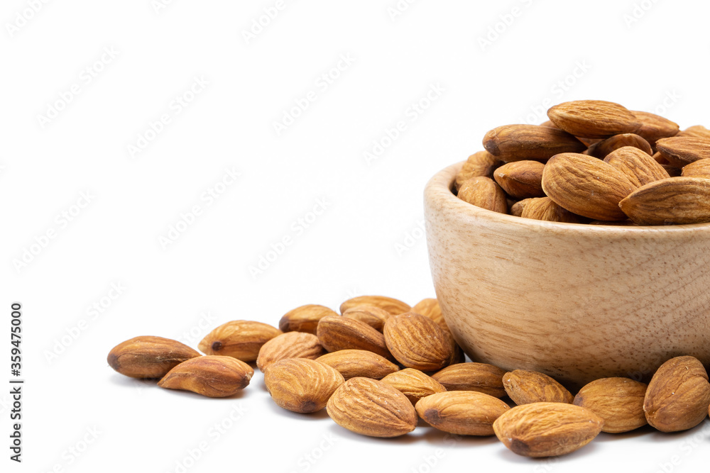 Wall mural almonds in wooden bowl isolated on white background