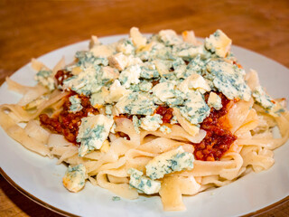 Homemade pasta with with minced meat and crushed blue mold cheese