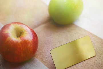 Two red and green apples lie on the bedspread. A sign to insert a logo or text