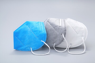 N95 masks in three colors are neatly placed against a gray background.COVID-19 Coronavirus outbreak.