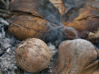 Fototapeta na wymiar Burnt coconut has a pleasant aroma, good taste and smoke in warm light background concept