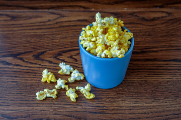 cheese popcorn in a blue mug on wooden table. close up
