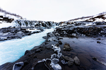 Incredible view of Bruarfoss Waterfall in winter. The 'Iceland’s Bluest Waterfall.' Blue water...