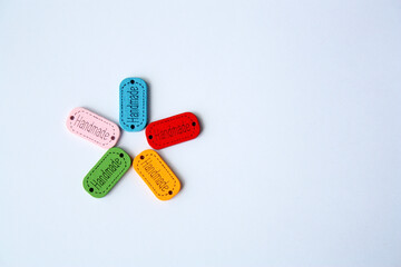 Wooden tags for needlework on a white background. Handmade multicolored labels in the shape of a flower. Handmade concept.
