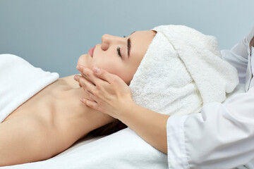Obraz na płótnie Canvas beautiful woman receiving facial massage. skin care, spa concept, treatment