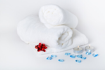 Spa towels, towels roll with hearts in the hotel's bedroom for design and decoration on white background. Copy space. Concept Happy Valentine's Day,  wedding,  honey moon or birthday. 