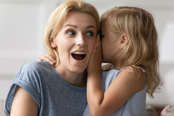 Close up image amazed mother hears incredible news from little daughter, kid girl share secret...