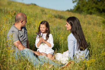 happy family in a meadow in sunny summer day