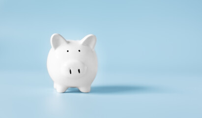 Piggy bank with copy space on blue background,front view