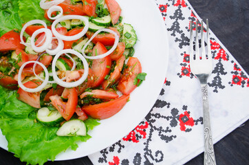 Salad with juicy tomatoes, lettuce, cucumber, red onion, arugula, dill and fresh parsley. Homemade food. The symbolic image. The concept of tasty and healthy vegetarian food. Top view and side view. 