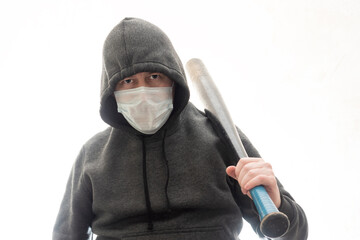 Criminal in a hoodie and mask with a black baseball bat on his shoulder