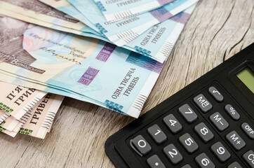 hryvnia and calculator on a wooden background. Close-up. Financial concept.