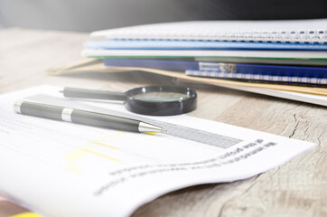 pen, magnifying glass and the working paper with a diagram