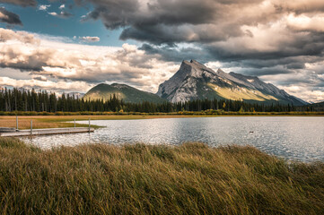 Mount Rundle with cloudy and wooden pier in Vermillion lake at Banff national park