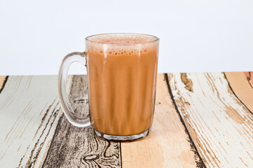 Teh tarik or pulled tea is a famous sweet milk tea in Malaysia. Bubble is floating on the surface of teh tarik.