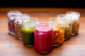 Nutrition concept - Healthy meals in glass jars over wooden background. Healthy food, Diet, Detox, Clean Eating or Vegetarian concept
