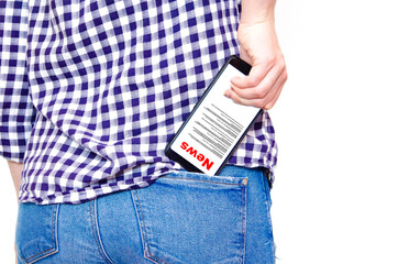 A young girl in a plaid shirt with a big booty and in jeans pokes and pokes a smartphone into the back pocket of jeans. Smartphone backwards and screen  forward