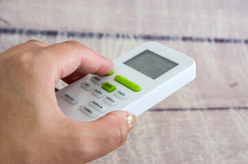 hand with air conditioner remote control Adjusting the air temperature using the remote control from the air conditioner.ir conditioner remote control. 