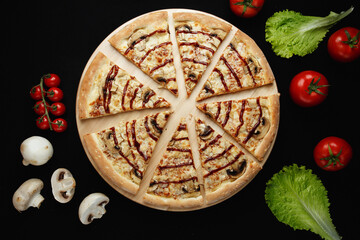 Pizza with ingredients on a black background. Top view.
